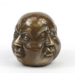 Chinese patinated bronze four sided Buddha head paperweight, character marks to the base, 11.5cm