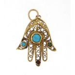Unmarked gold Hand of Fatima pendant set with semi precious stones including turquoise and garnet,