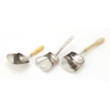 Three Georgian silver caddy spoons including two with ivory and mother of pearl handles, one by