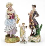 Three hand painted porcelain figurines including one of a figure wearing a blue coat holding a