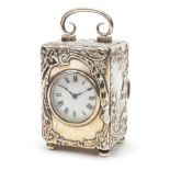 Victorian silver cased carriage clock by William Comyns, embossed with figures seated in a