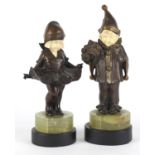 Pair of Art Deco patinated bronze ivory and onyx figures of children raised on black slate bases,