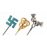 Three hat pins including an unmarked gold and enamel swastika, the largest 25.7cm in length :For