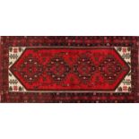 Rectangular Persian red ground rug having an all over geometric design, 200cm x 101cm :For Further