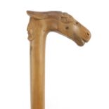 Continental walking stick with carved Cypriot head and horse head handle, 89cm in length :For