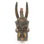 Large tribal carved wood dragon face mask with green and red painted decoration, 57cm high :For