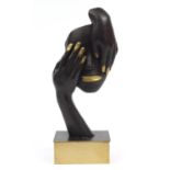 Modernist patinated brass sculpture of two hands and a mask, raised on a rectangular block base