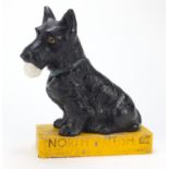 Rare North British Golf ball advertising pottery figure of a Scottie dog holding a golf ball on