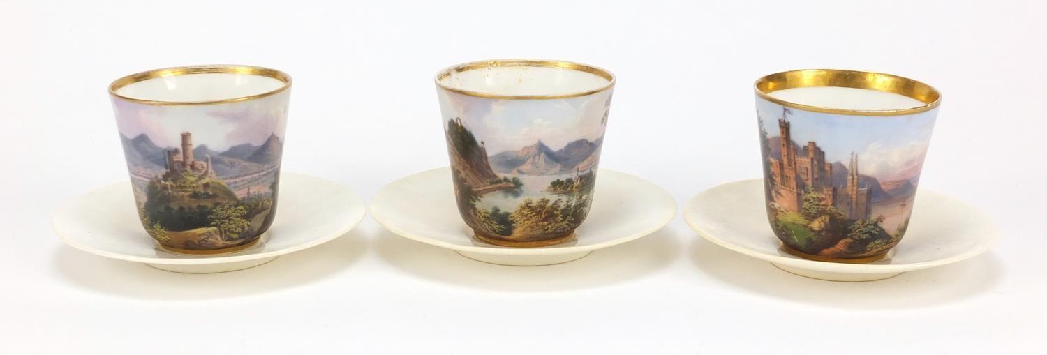 Three 19th Century continental porcelain cabinet cups and saucers, each cup finely hand painted with