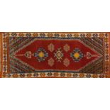 Red ground geometric pattern rug, 140cm x 63cm : For Further Condition Reports Please visit Our