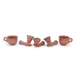 Turkish Tophone terracotta, comprising three pipe bowls and two cups, each with incised decorations,