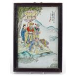 Chinese porcelain panel housed in a hard wood frame, hand painted with figures beside water,