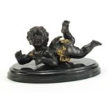 Classical patinated bronze figure of Putti raised on an oval marble base, 18.5cm wide :For Further
