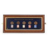Glazed display of 20th century monarchs pennies and stamps with certificate of authenticity, 40cm