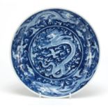 Chinese blue and white porcelain shallow dish hand painted with dragons amongst clouds chasing a