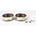 Pair of circular silver and oak wine coasters by Carrs and two silver mustard spoons, the coasters