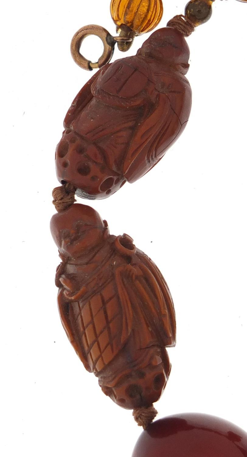 Chinese cherry amber coloured bead and carved coquilla nut necklace, 40cm in length :For Further - Image 3 of 4