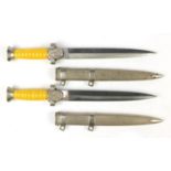 Two German military interest daggers with scabbards, 39cm in length :For Further Condition Reports