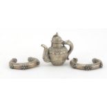 Tibetan Unmarked silver miniature teapot and two silver coloured metal slave bangles, the teapot 7cm