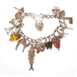 Silver charm bracelet with a selection of mostly silver charms including articulated fish, camel and