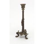 19th century patinated bronze candlestick with paw feet, the column decorated in relief with a