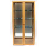 Beech illuminated display cabinet by John Coyle, with three glass shelves and mirrored back, 191cm H