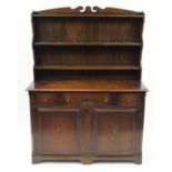 Oak dresser with open plate rack above three drawers and a pair of cupboard doors, with Birchcraft