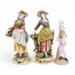 Pair of 19th century Continental porcelain figurines and a figural candlestick, the largest 29.