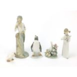 Collectable china including Lladro penguin and figurine of a girl holding an instrument, the largest