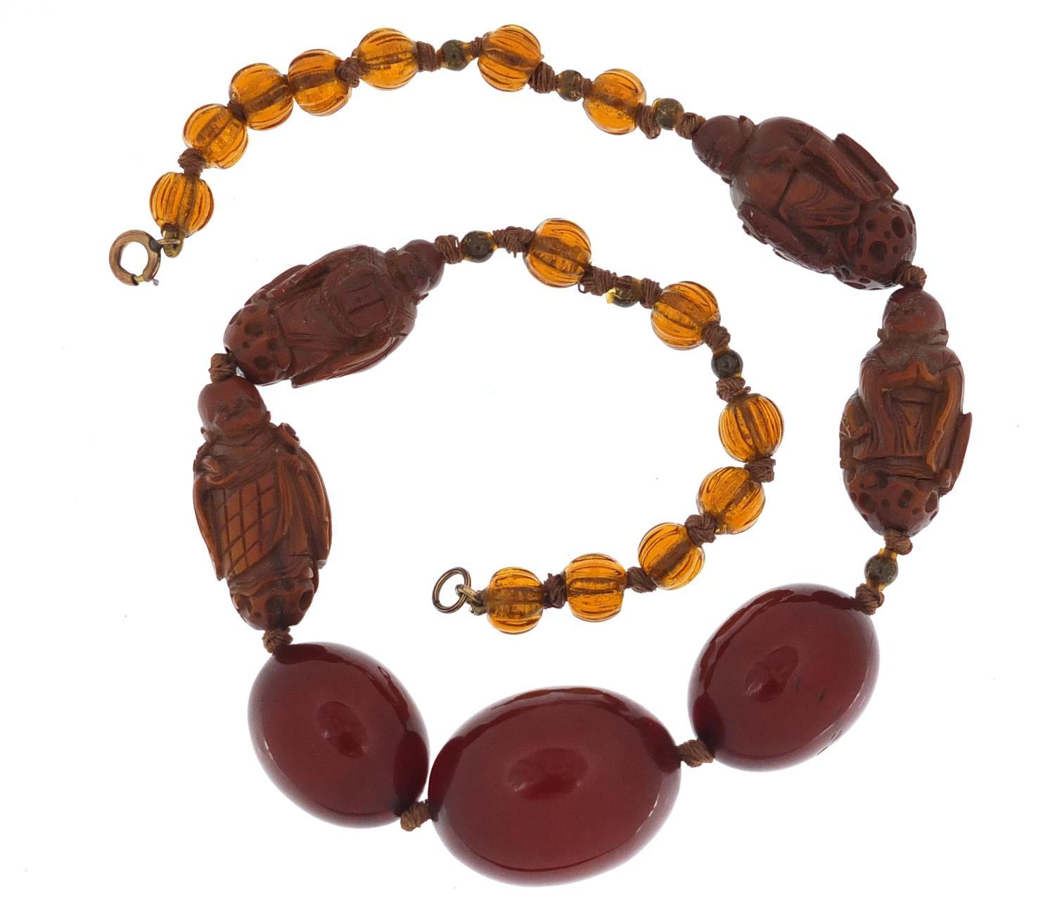 Chinese cherry amber coloured bead and carved coquilla nut necklace, 40cm in length :For Further