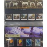 Collection of Royal Mint presentation packs arranged in an album, various genres and