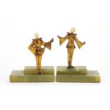 Pair of Art Deco musicians with carved ivory heads, raised on rectangular stepped onyx bases, the