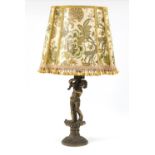 Ornate gilt metal table lamp with shade in the form of a semi nude young boy holding a cornucopia,