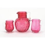 Three Victorian cranberry glass jugs, the largest 15.5cm high :For Further Condition Reports