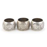 Set of three Indian unmarked silver napkin rings, embossed and engraved with foliage, (tests as