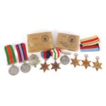 Seven British military World War II medals, two boxes of issue and a Bedfordhire & Hertfordshire cap