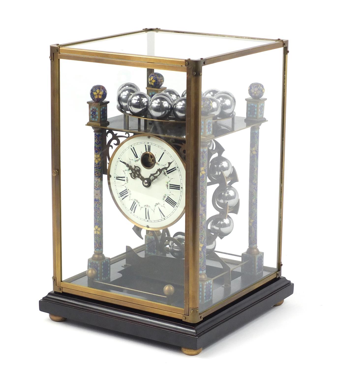 Champlevé enamel rolling-ball clock with enamel dial, having Roman numerals and glass case,