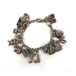 Silver charm bracelet with selection of mostly silver charms including animals, chamber stick, dog