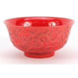 Chinese red ground porcelain bowl decorated in relief with dragons amongst clouds, six figure