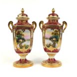Pair of Noritake twin handled vases and covers, each hand painted and gilded with landscapes and