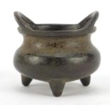 Chinese patinated bronze tripod incense burner with twin handles, four figure character marks to the