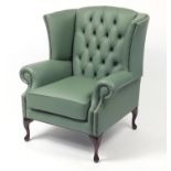 Contemporary wingback armchair with sage green leather buttonback upholstery, 103cm high :For