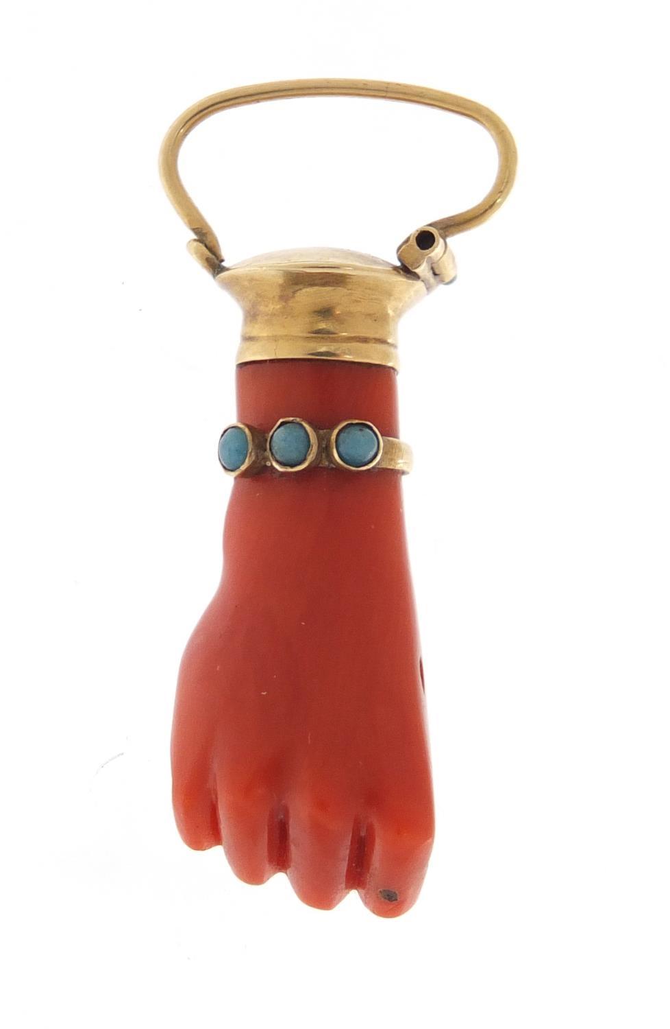 Victorian carved coral pendant in the form of a clutched hand with unmarked gold mounts and