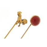 Two Victorian unmarked gold tie pins including a cockerel and one set with a cabochon carnelian, the
