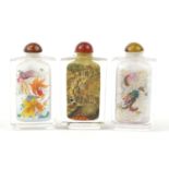 Three Chinese glass snuff bottles internally hand painted with dragons, figures and fish, each 8.5cm