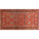 Rectangular Persian rug having a floral design central field onto a red ground, 190cm x 100cm :For