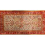 Rectangular Persian rug with orange ground border having a repeat flower head design, 236cm x