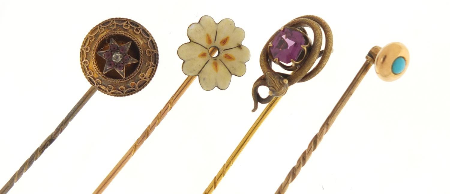 Four Victorian unmarked gold and gilt metal tie pins including a serpent and one set with a