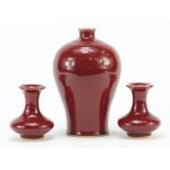 Three Chinese porcelain sang de boeuf glazed vases including a pair, each with character marks to
