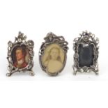 Three miniature sterling silver easel photo frames, one decorated with a Art Nouveau female, each